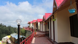 A row of buildings with red roofs and a pathway leading to them.