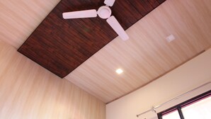 A ceiling fan with four blades, wooden paneling, and recessed lighting.