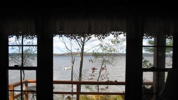 A room with a view of a lake, a wooden deck, and a railing. - Three month rental minimum.   (Greenland)
