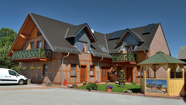A traditional chalet-style hotel with multiple gabled roofs, wooden balconies, and a well-maintained garden. - Villa Rosamunde (Burg (Spreewald))
