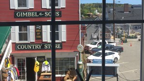 Un edifici vermell amb un rètol que diu 'GIMBEL & SO'S' i un rètol que diu 'COUNTRY STORE'.