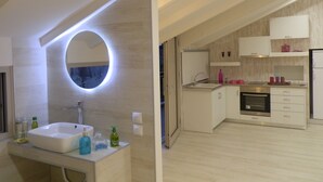 A modern kitchen with a built-in oven, a sink, and a countertop with various items. - Villa Daizy (Zakynthos)