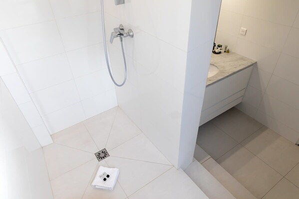 A bathroom with a shower, a sink, and a toilet. - Orange Vendome - Bright 1-Bed Apt Near the Louvre (Paris)