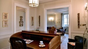 A dining area with a wooden table, chairs, a chandelier, and artwork on the walls. - Luxury Suite Apartment of 200sqm with terrace (Firenze)