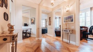 A spacious hallway with wooden flooring, a dining area with a table and chairs, and a seating area with a sofa. - Luxury Suite Apartment of 200sqm with terrace (Firenze)
