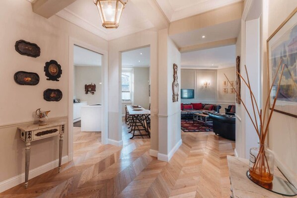 A spacious living area with a dining table, a sofa, and a TV. - Luxury Suite Apartment of 200sqm with terrace (Firenze)