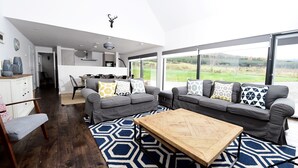 A modern living room with a grey sofa set, a wooden coffee table, and a patterned rug. - Stunning 4 bedroom countryside retreat (Aberlour)