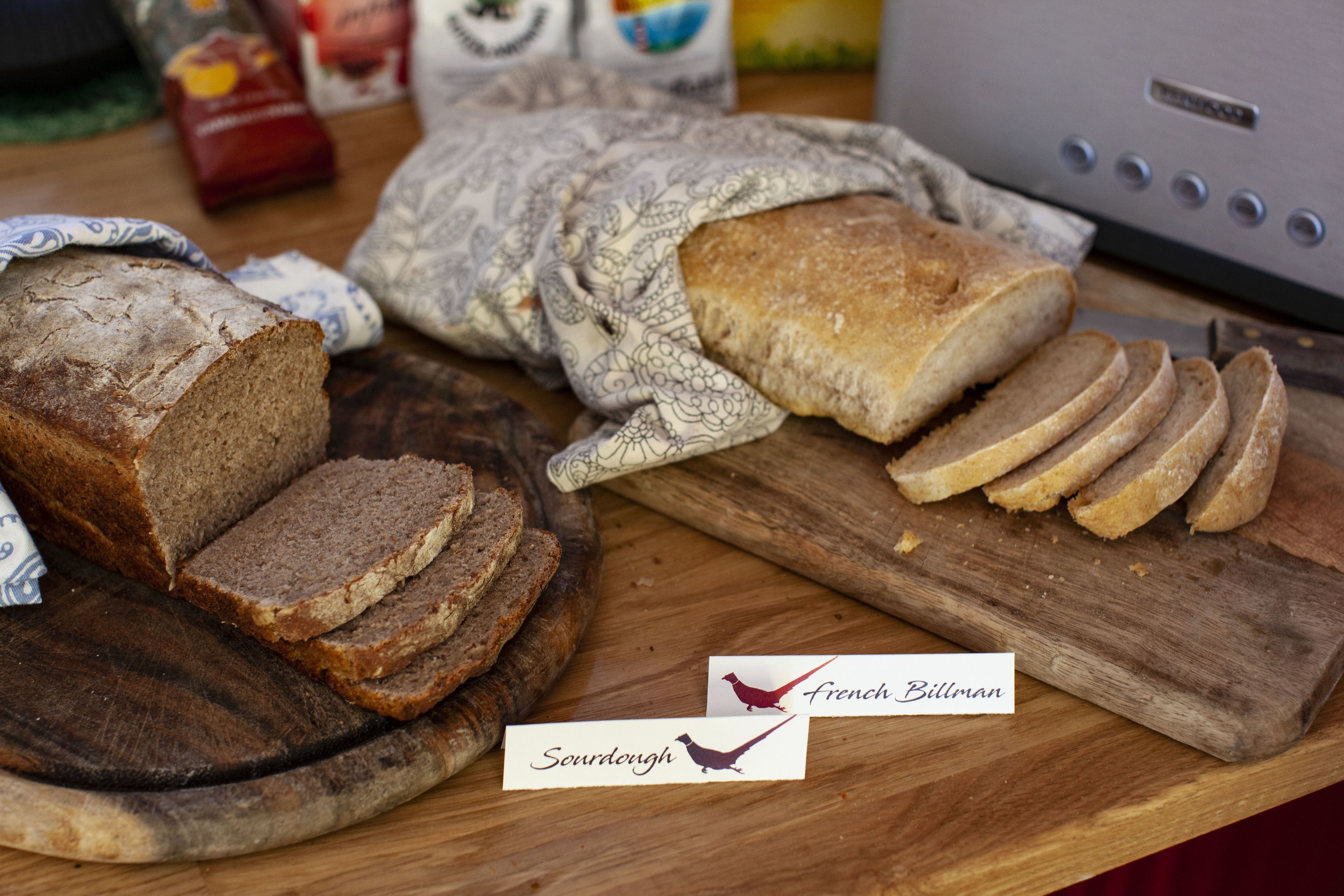 A loaf of bread and sliced bread on a wooden cutting board.
