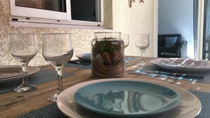 Mesa posta com pratos, copos e um pote decorativo.