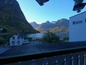 A lakeside hotel with a view of mountains and a clear sky. - Hjelle Hotel (Stryn)
