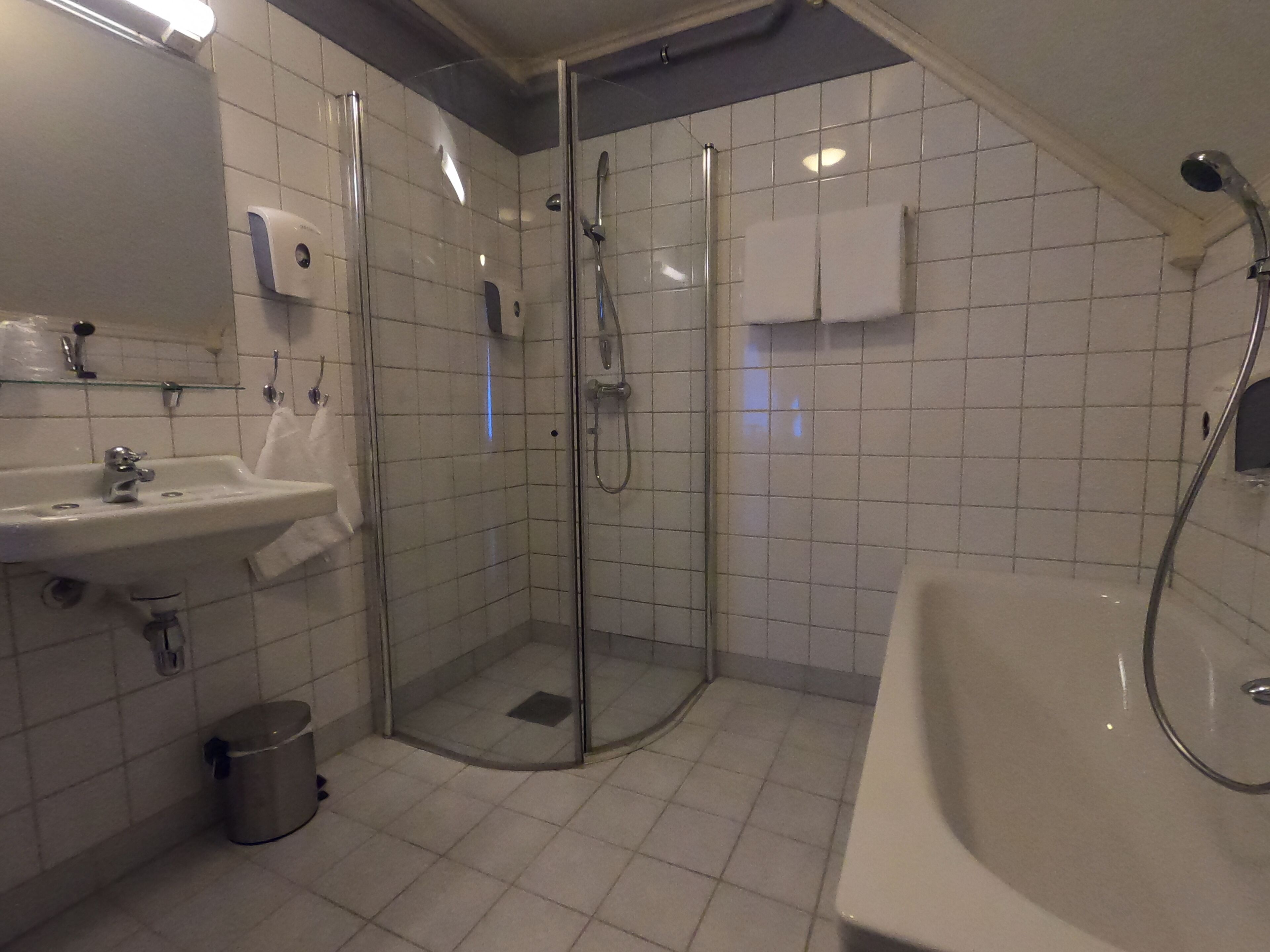 Un baño moderno con ducha de vidrio, lavamanos y bañera.