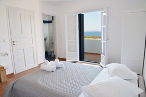 Une chambre avec un lit, des serviettes, une salle de bain et un balcon avec vue.
