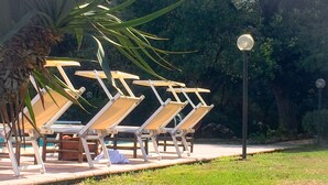 A poolside area with lounge chairs and a lamp post. - Lisetta Holiday homes - Ladybug House - Family House (Perugia)