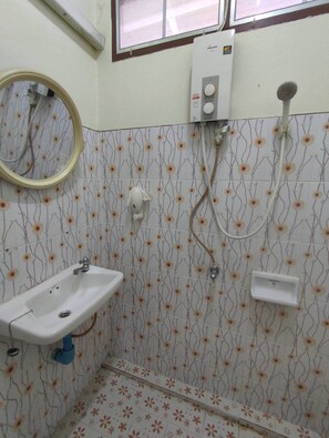 Un baño con lavamanos, espejo, inodoro y ducha.