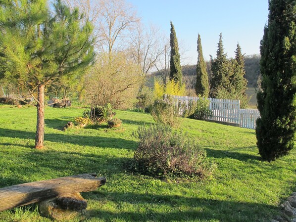 A grassy outdoor area with various trees and a wooden fence. - Les Roulottes du Lauragais (Montmaur)