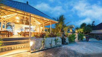 A covered outdoor seating area with stone steps leading up to a bar area.