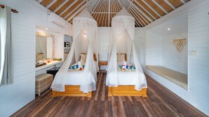 A room with two wooden beds, white walls, a wooden ceiling, and a small bench. - The Cubang Huts Lembongan (Lembongan Island)