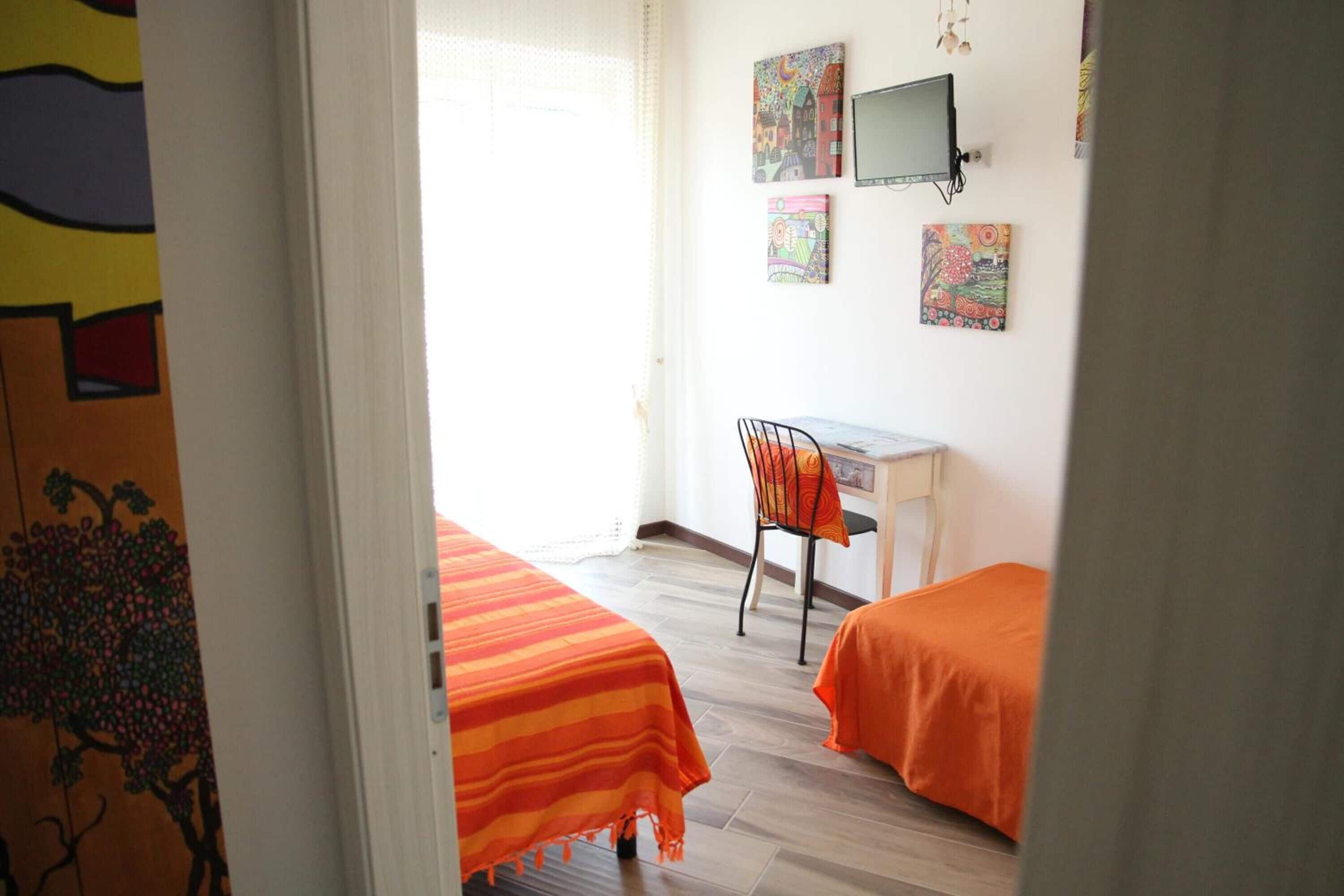Une chambre avec deux lits, un bureau et une chaise.