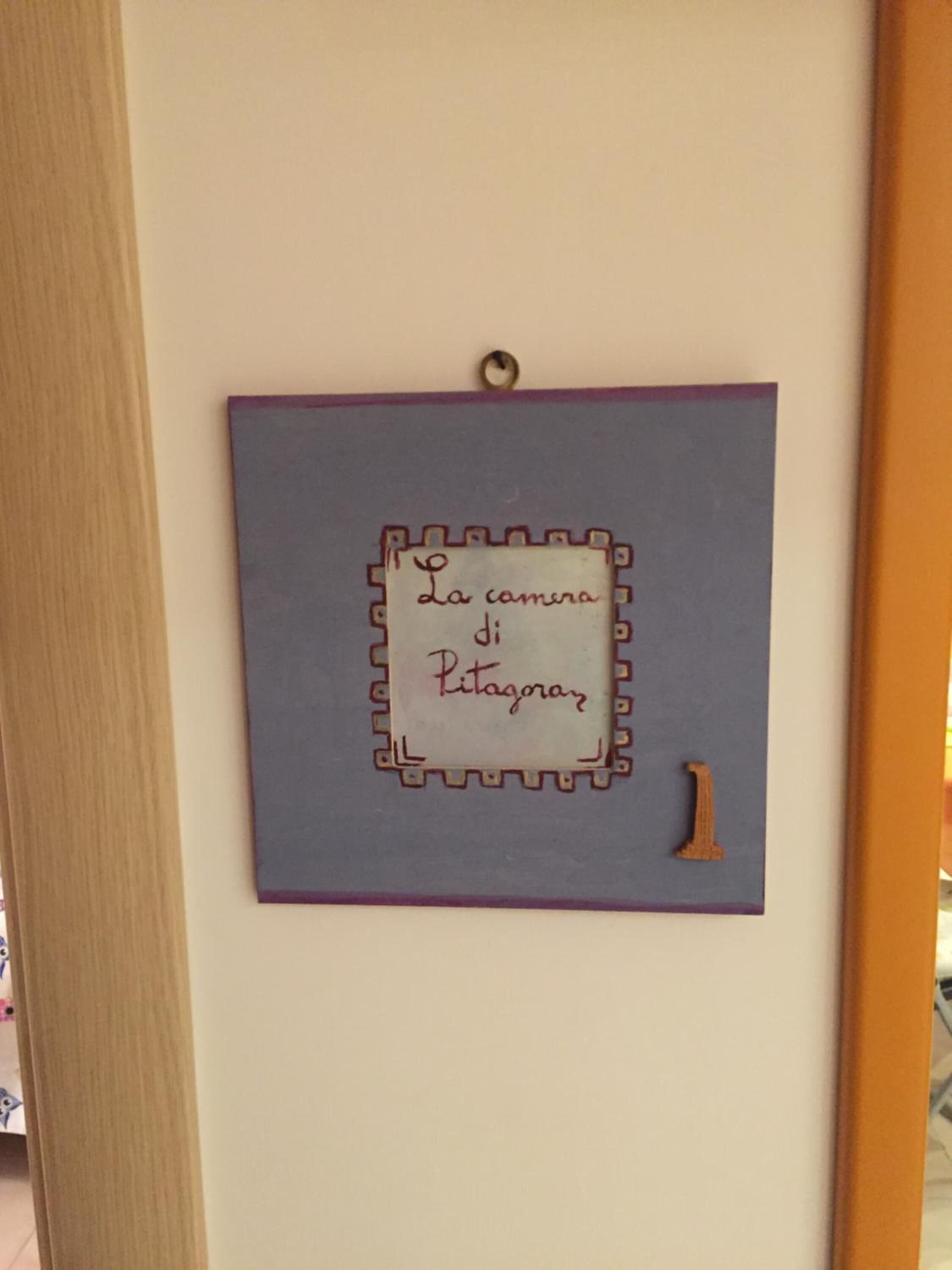 A wall-mounted sign with a decorative border and a number '1' below it.