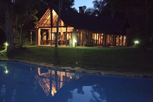 Un edificio de madera amplio y bien iluminado con una piscina al frente.