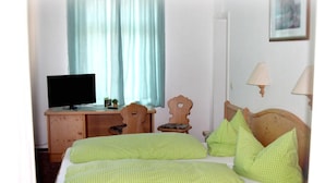 Een hotelkamer met een bed, een bureau met een computer, een stoel en een lamp.