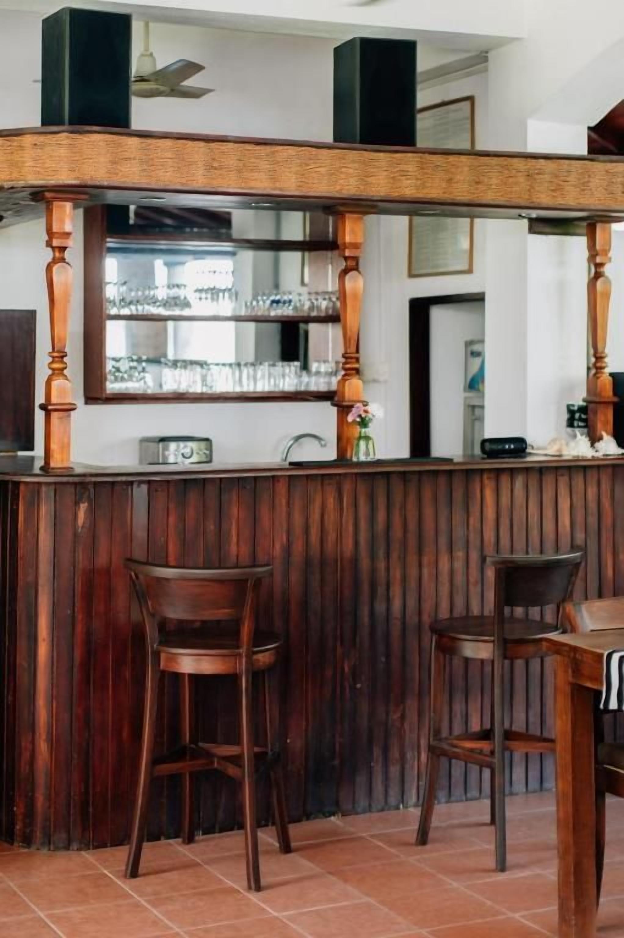 A bar area with wooden stools and a counter.