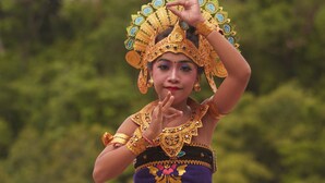 A person in traditional attire by a body of water.