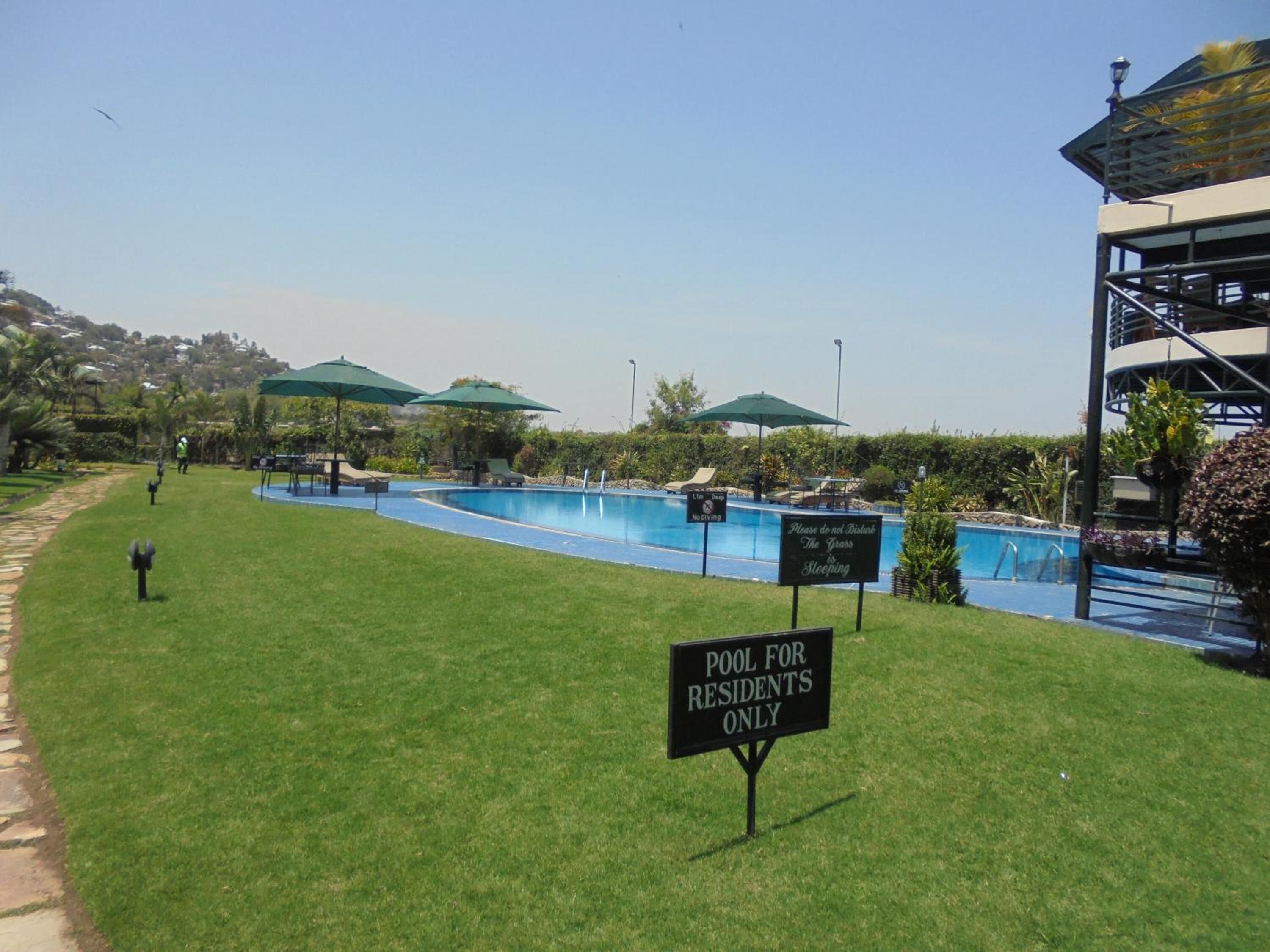 Zona de piscina residencial con un cartel que indica que es solo para residentes.