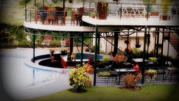 A pool area with a circular deck, outdoor seating, and potted plants. - Ryan's Bay Hotel (Mwanza)