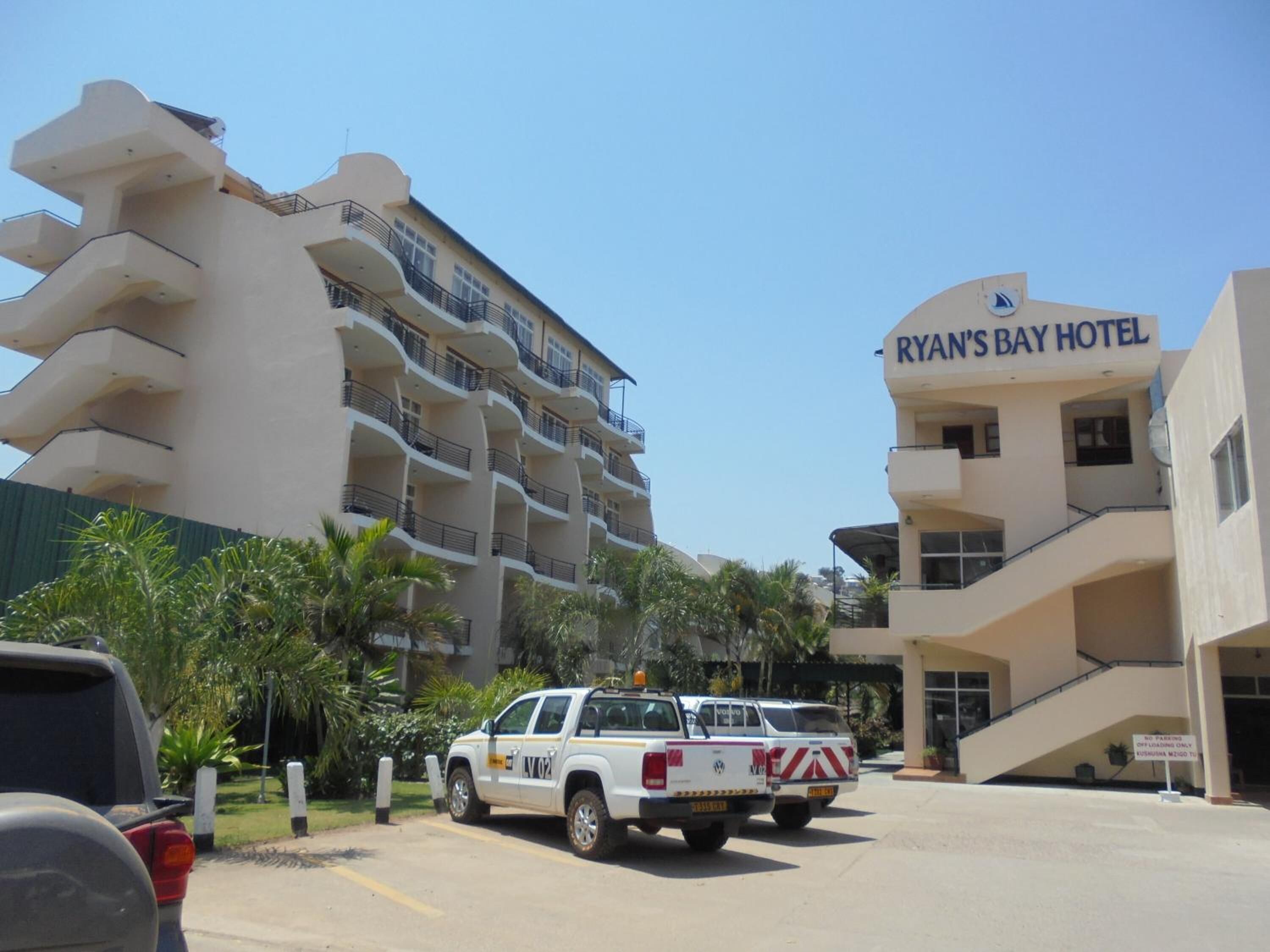 A multi-story hotel with a sign reading "RYAN'S BAY HOTEL".