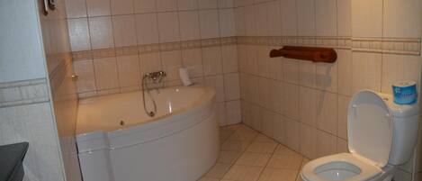 A bathroom with a bathtub, toilet, and a towel rack.