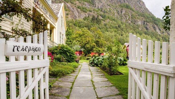A stone pathway leading to a hotel entrance with a sign reading "reception." - Walaker Hotel (Luster)