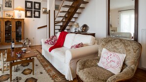 A living room with a white sofa, a patterned armchair, a wooden coffee table, and a staircase. - Villa Bramasole ,big pool , View 200m sea, Kamenjak Park, EV charging available (Premantura)