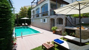A modern house with a swimming pool, outdoor seating, and a garden. - Villa Bramasole ,big pool , View 200m sea, Kamenjak Park, EV charging available (Premantura)