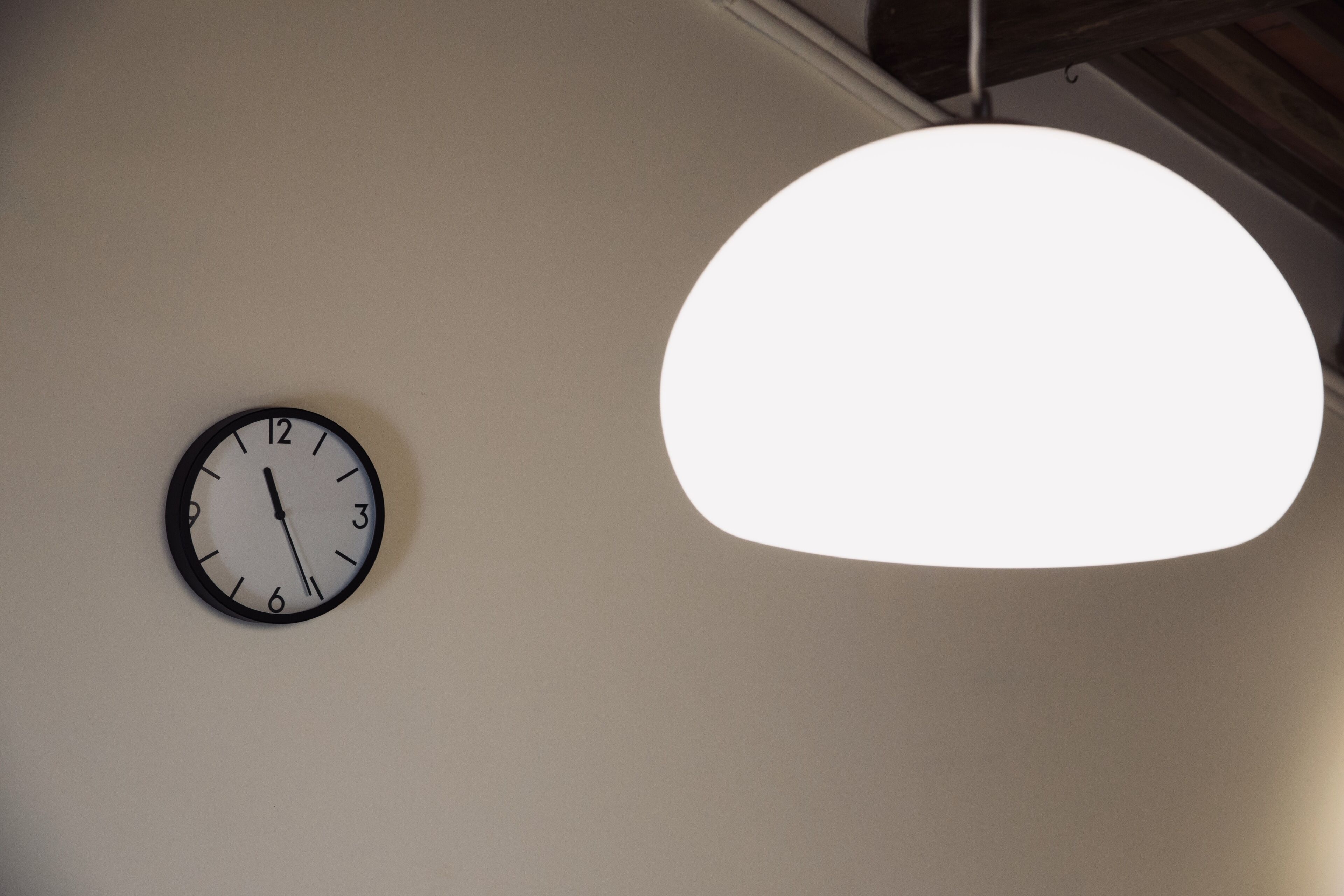 A wall clock and a hanging light fixture.