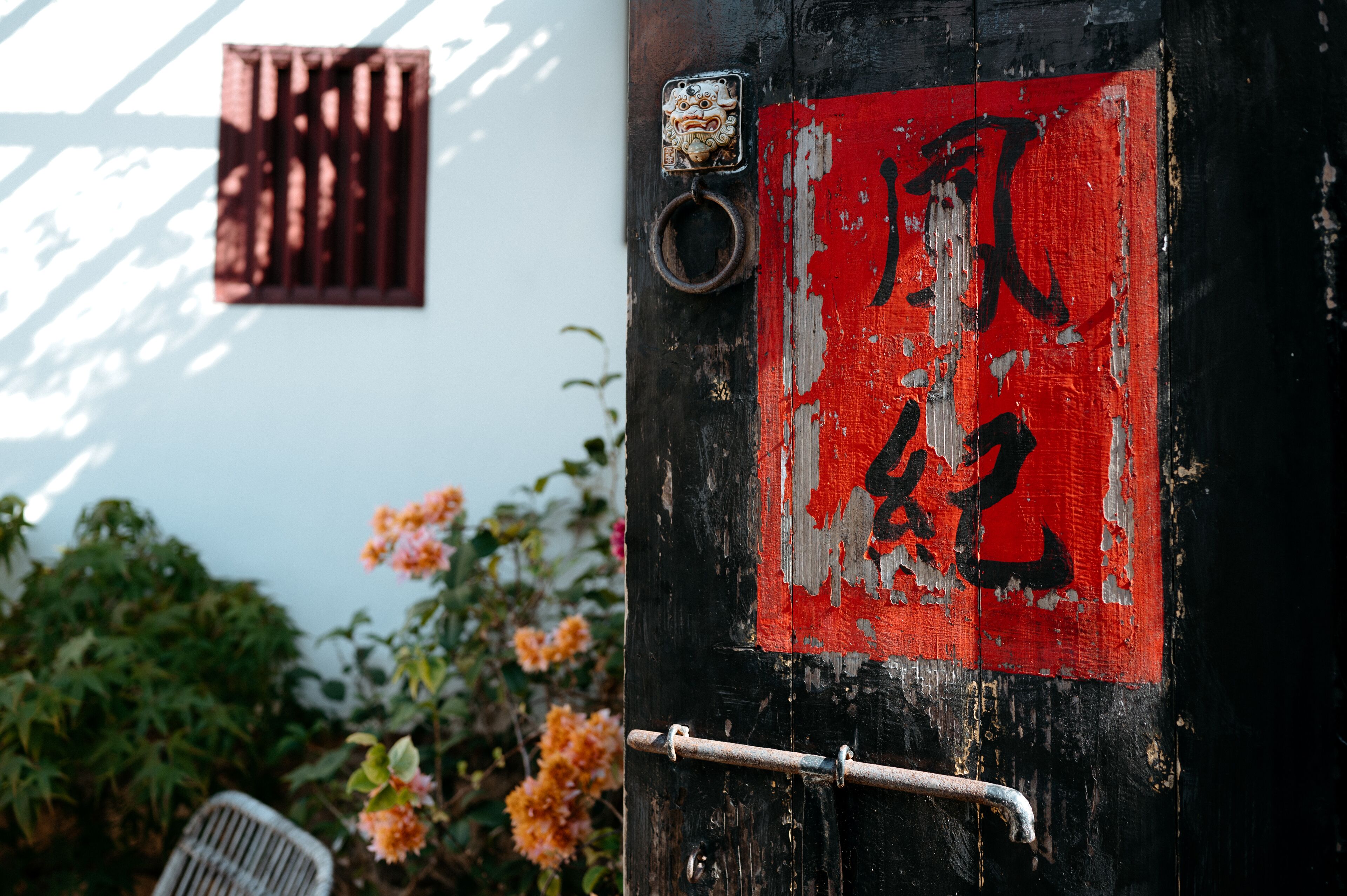 A weathered door with a red sign and a metal handle.