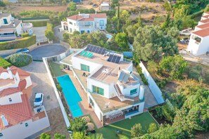 Eine moderne Villa mit Pool auf dem Dach, Solaranlage und üppigem Garten.