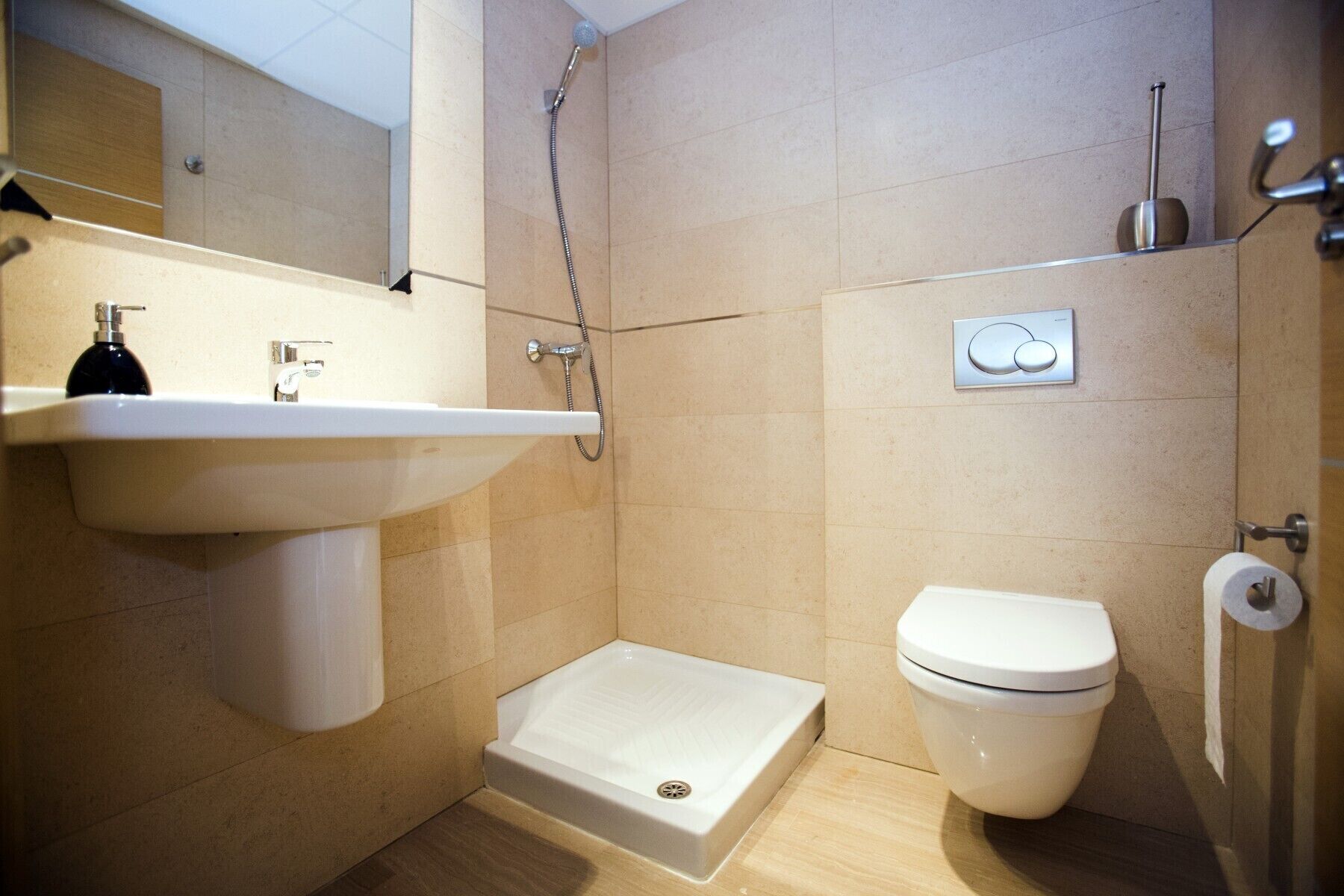 Une petite salle de bain avec un lavabo, des toilettes et une douche.
