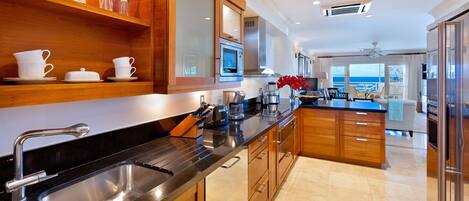 A modern kitchen with stainless steel appliances, wooden cabinets, and a large island.