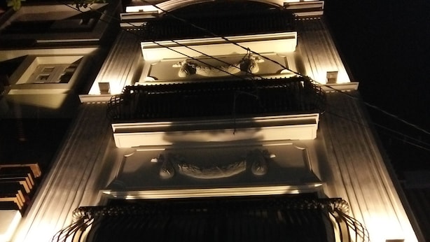 A building with a prominent entrance, a staircase, and an illuminated exit sign. - R&G Suite (Ho Chi Minh City)