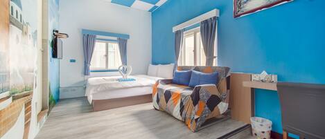 A bedroom with a bed, a desk, and a window.