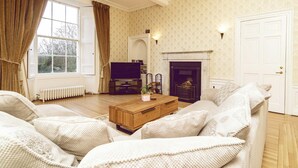 A cozy living room with a fireplace, a television, and comfortable seating. - A Georgian Masterpiece Steps from Stirling  (Stirling)