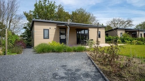 A modern two-story house with a gravel driveway and a small garden area. - Europarcs Markermeer (Bovenkarspel)