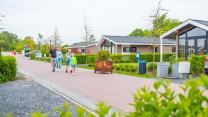 A pathway leading to modern buildings with a sign for 'DunParks'. - Europarcs Markermeer (Bovenkarspel)