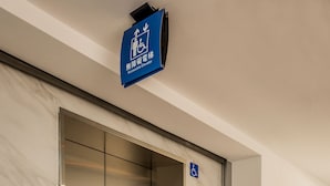 Un ascenseur doté d’une signalétique bleue indiquant qu’il est accessible aux personnes à mobilité réduite.