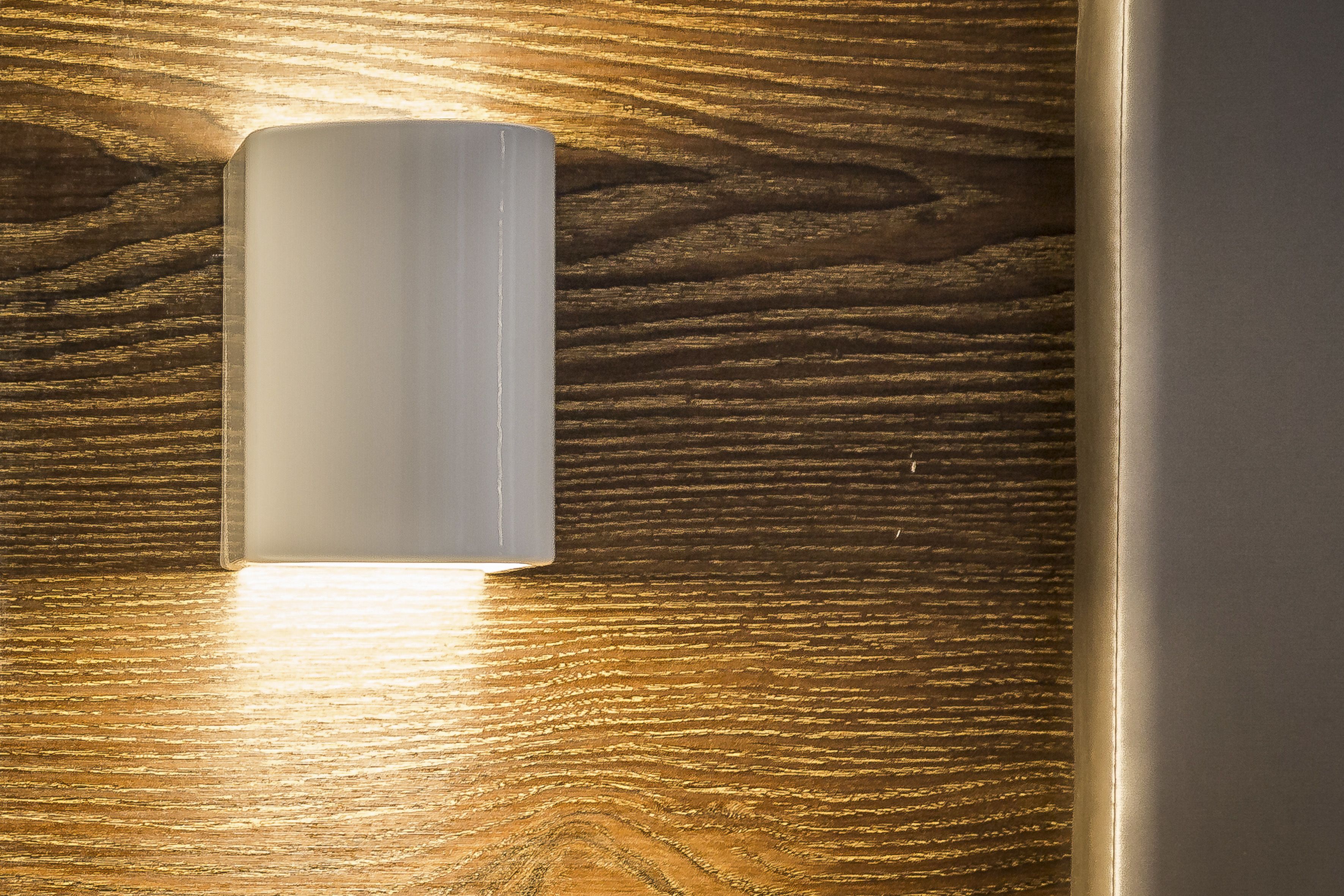 A wall-mounted light fixture on a wooden surface.