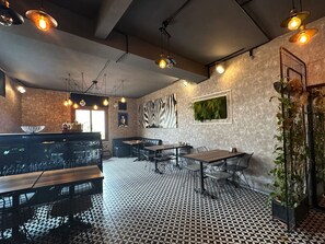 A restaurant interior with a patterned floor, black and white seating, and pendant lighting. - Black Art Otel (Istanbul)