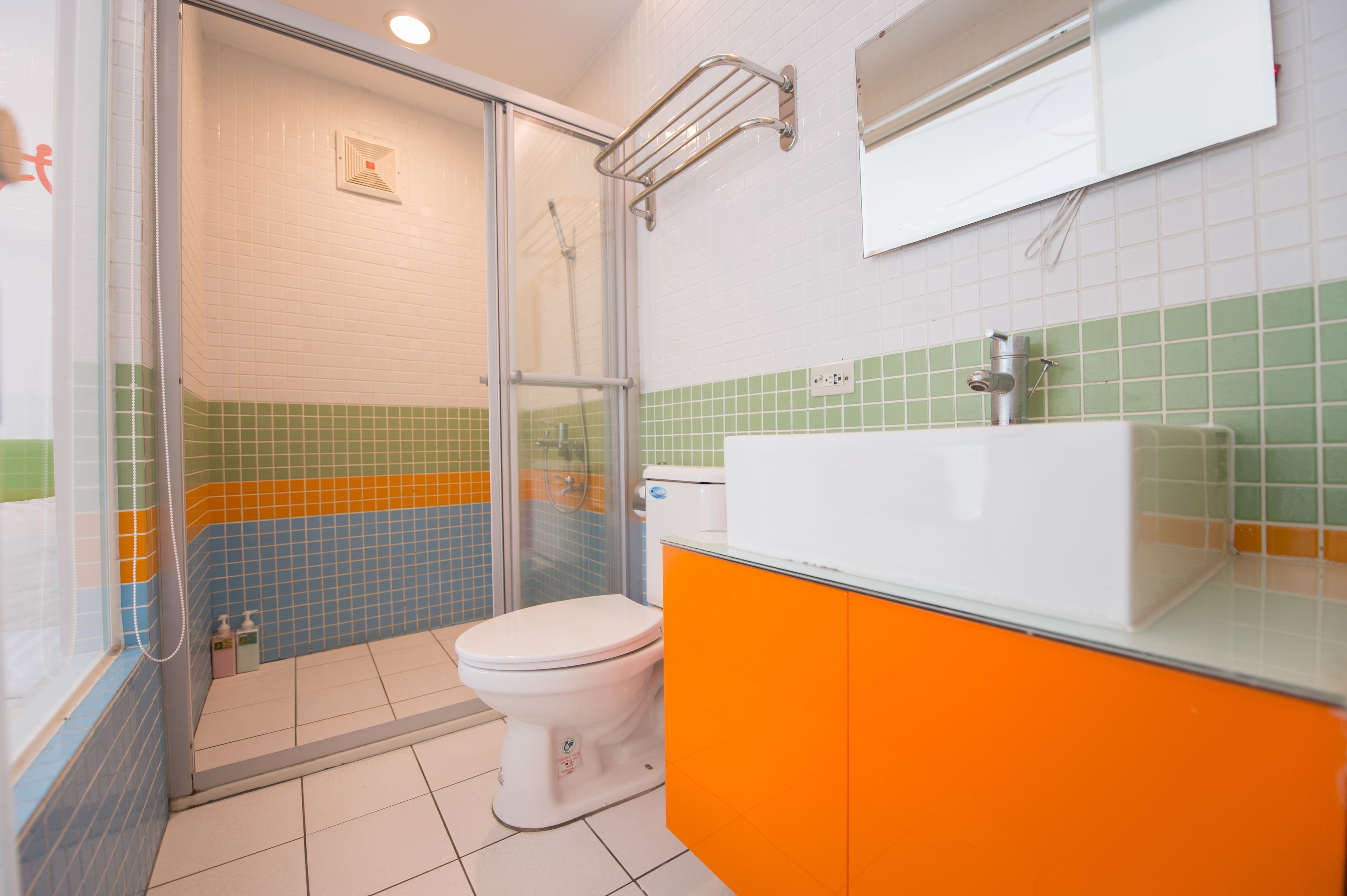 A bathroom with a shower, toilet, and sink.