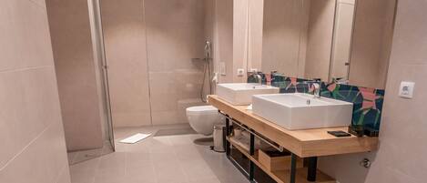 Un baño moderno con bañera, dos lavamanos y ducha.