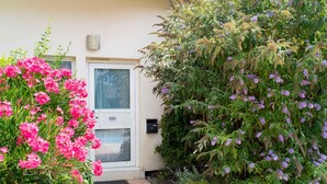 A house with a door marked '806', surrounded by lush greenery and flowering plants. - Allotel (Fos-sur-Mer)
